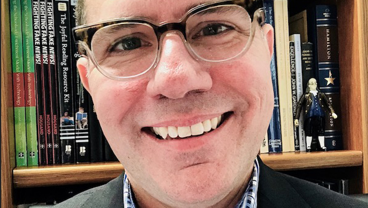 Headshot of Brian Housand wearing brimmed glasses
