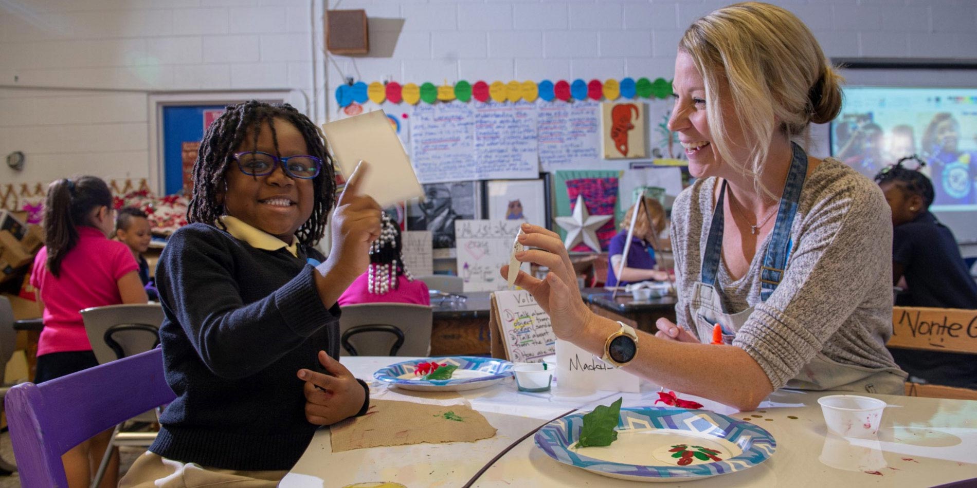 Watson student painting with an elementary student