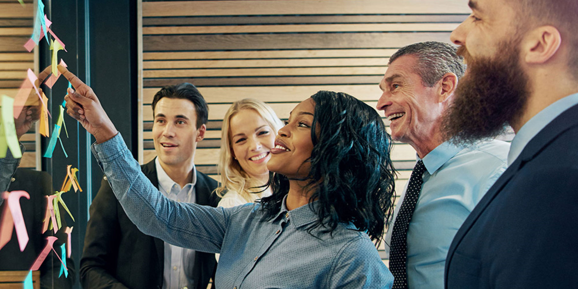 Executives putting sticky notes on a wall