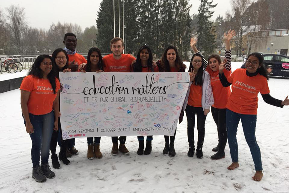 Group of Watson students wearing matching outdits holding an Education Matters sign