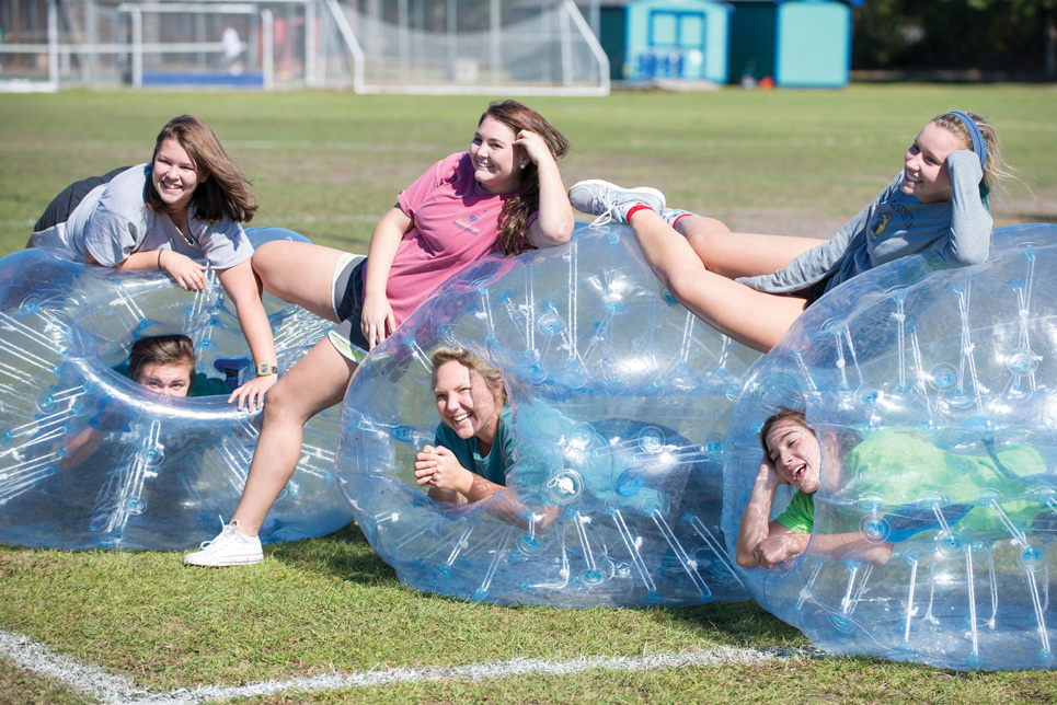 6 Watson students playing around with giant inflatable balls