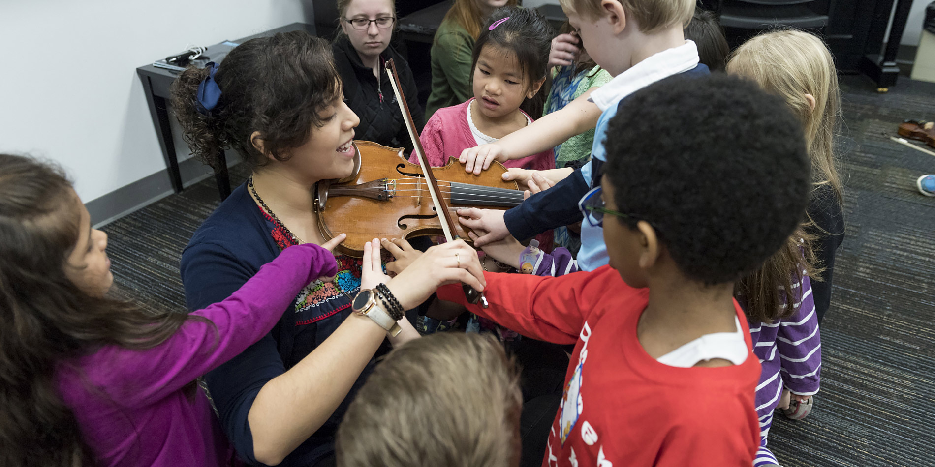 Woman playing violin in classroom.