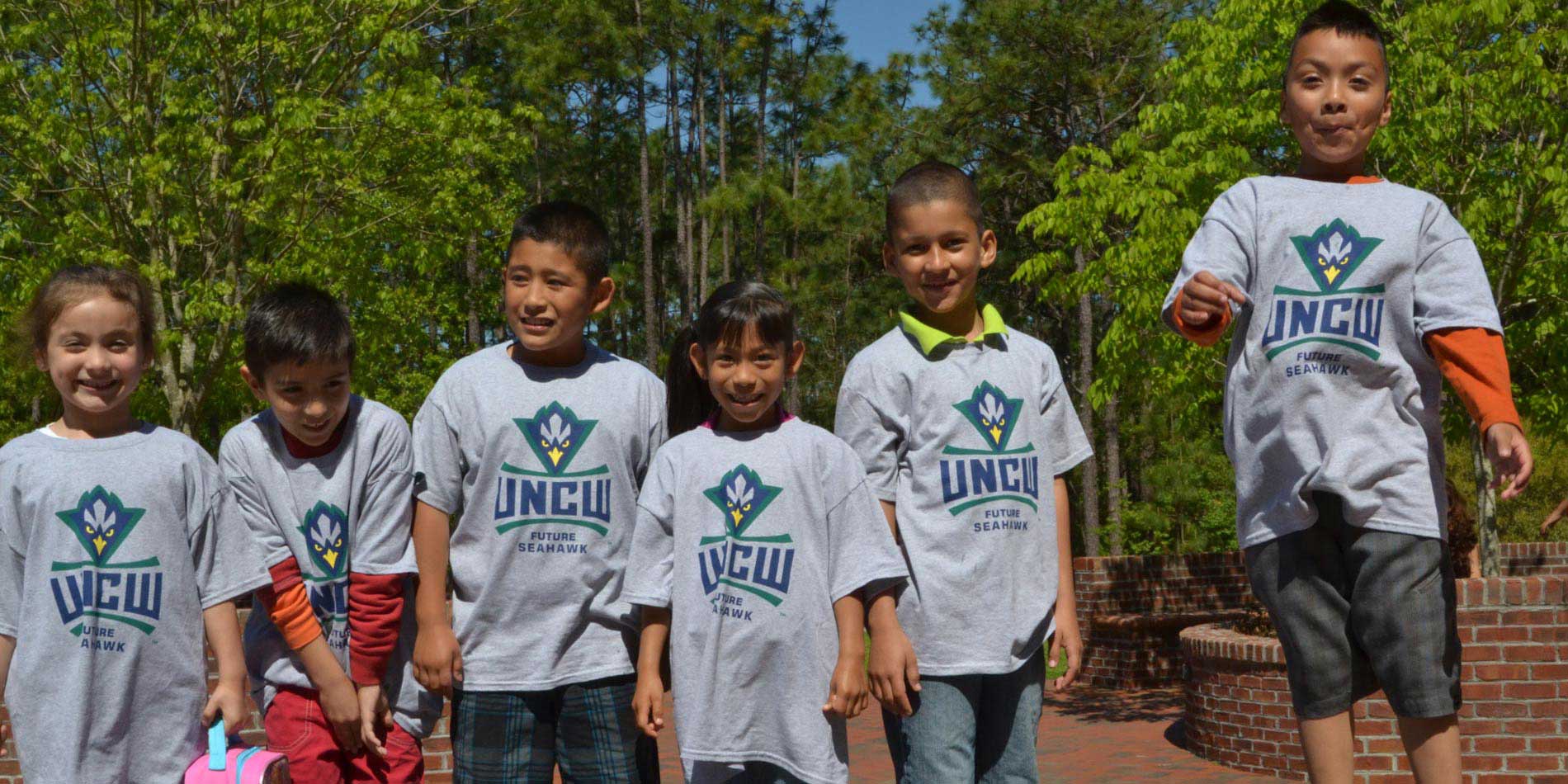 Group of elementary students wearing UNCW tee shirts