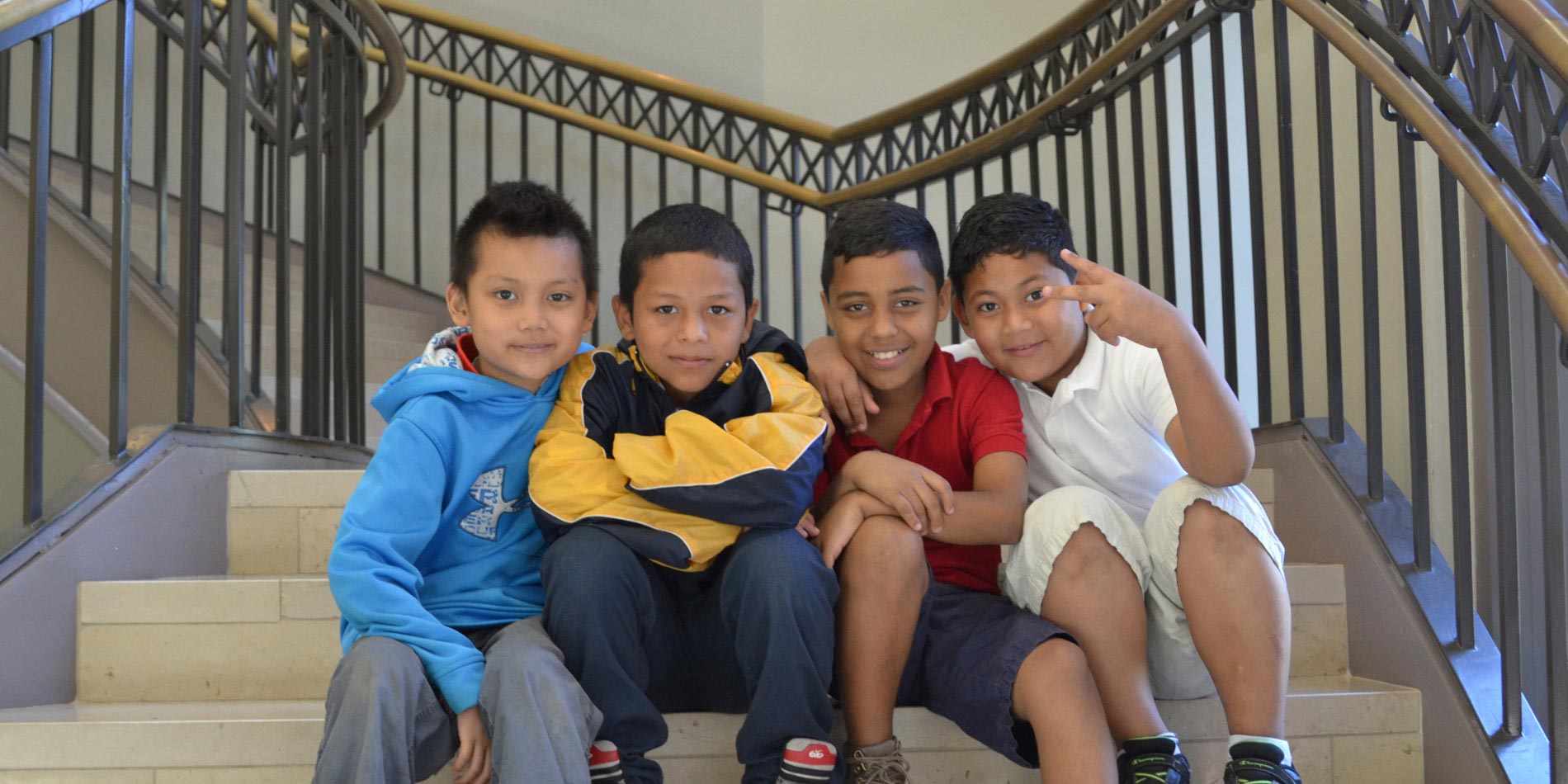 Four elementary students sitting on the spiral staircase in Watson