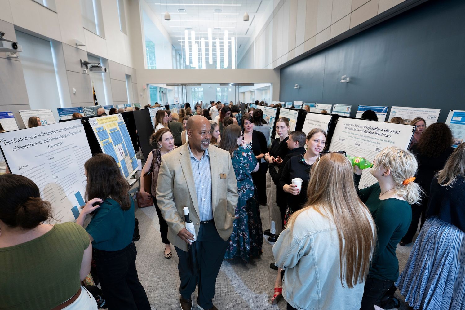 Faculty, staff and students interact during the 2025 research poster showcase.  