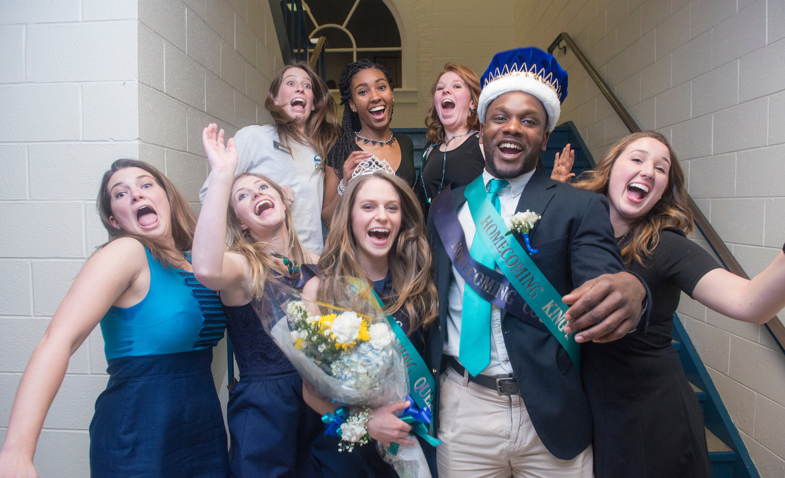 Homecoming king and queen in stairwell with other people