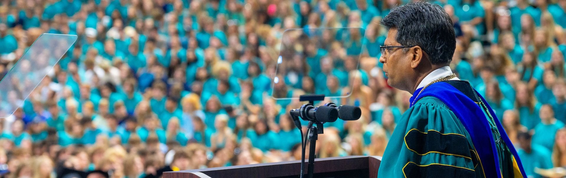 First-Year Students wearing teal take a photo on Convocation day in front of the UNCW clocktower