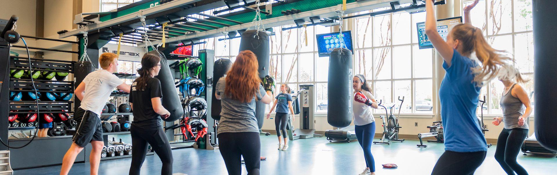 Campus Recreation members are shown participating in a kickboxing group fitness class in the Harris Teeter Functional Training Area