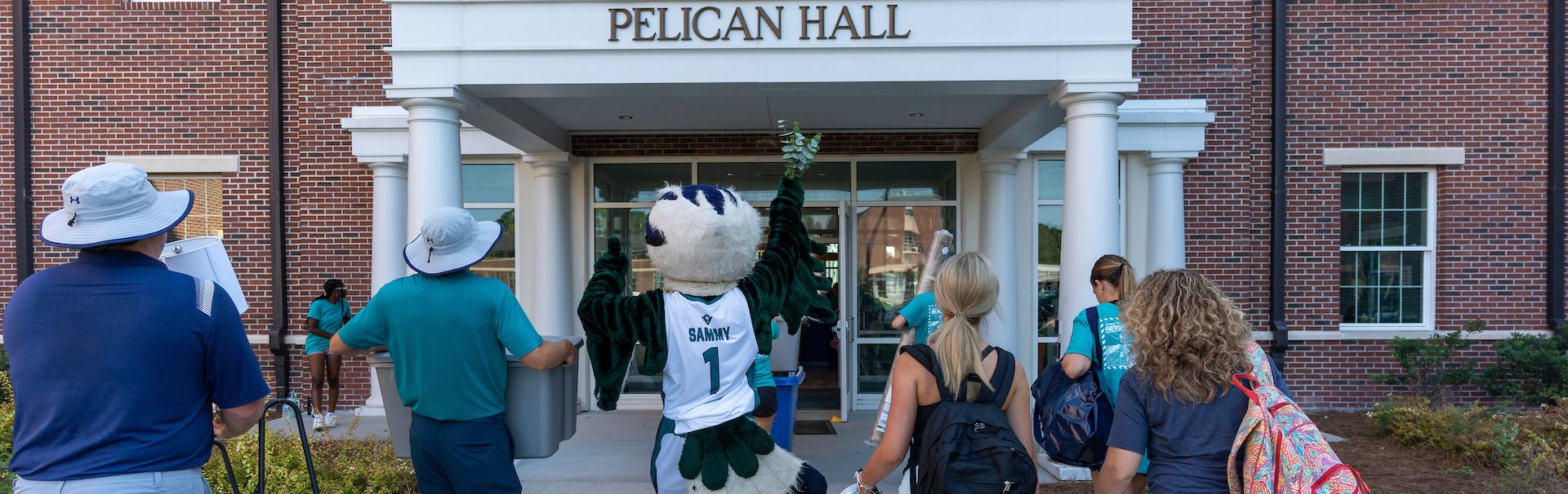 Returning students move into Pelican hall with Sammy C Hawk Leading the way.