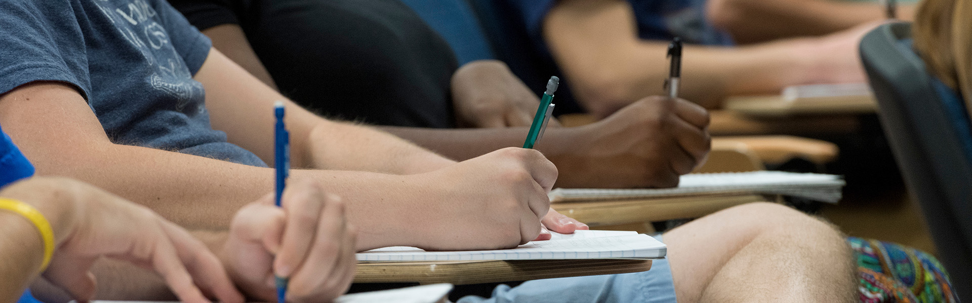 Student hands taking notes during lecture
