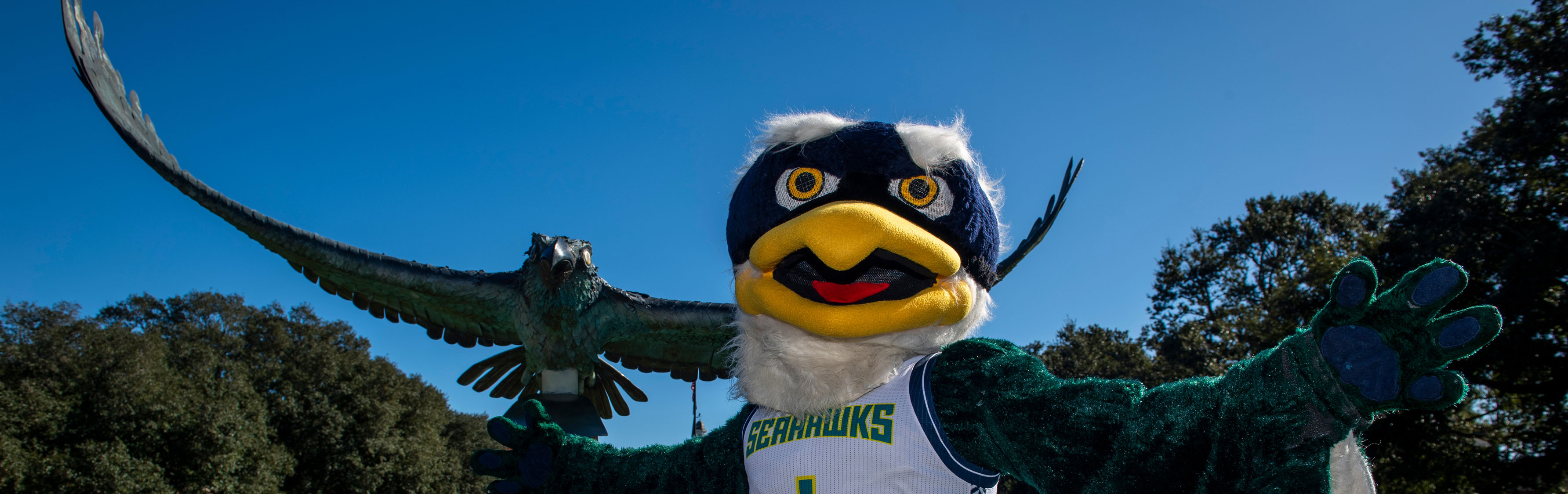 Mascot Sammy Seahawk in front of the Soaring Seahawk statue