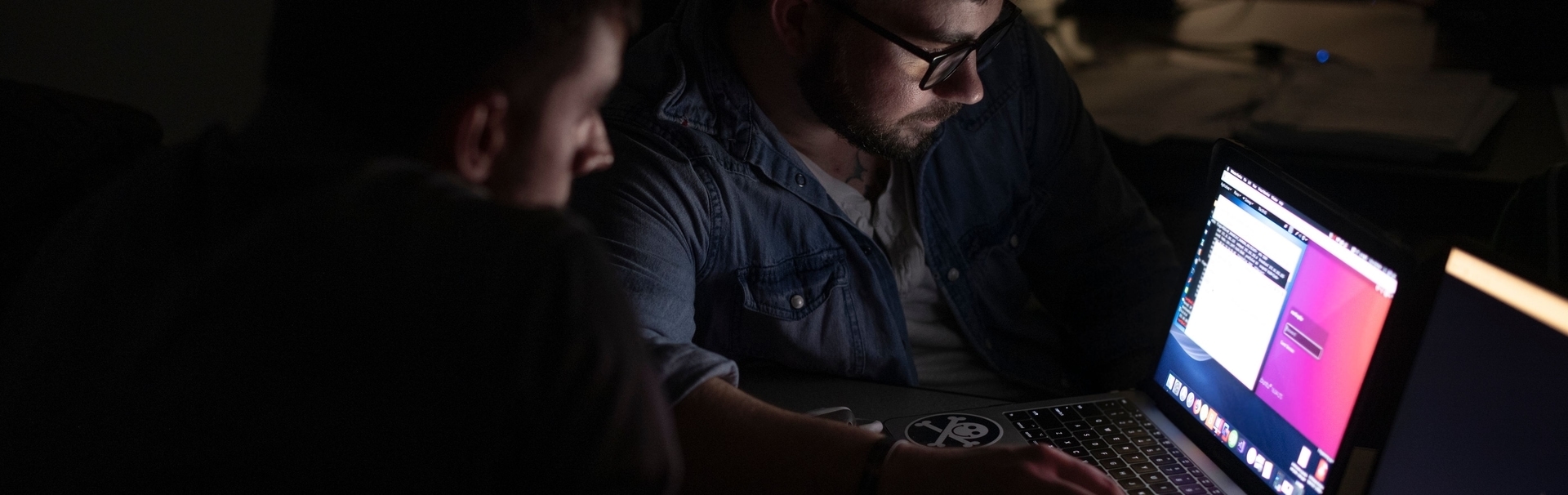 students working on laptop in dark