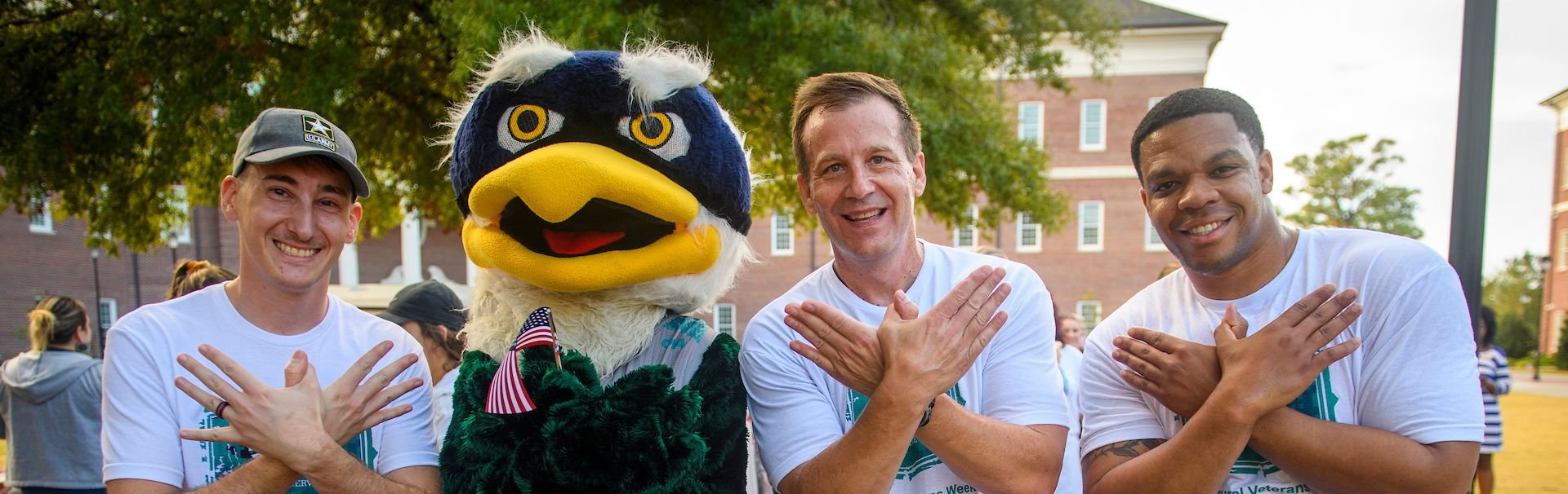 veterans making uncw eagles with their hands