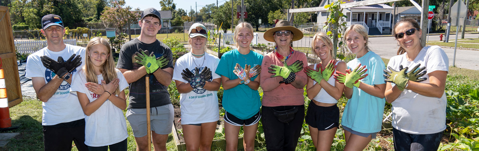 People pose with gloves after completing yard work