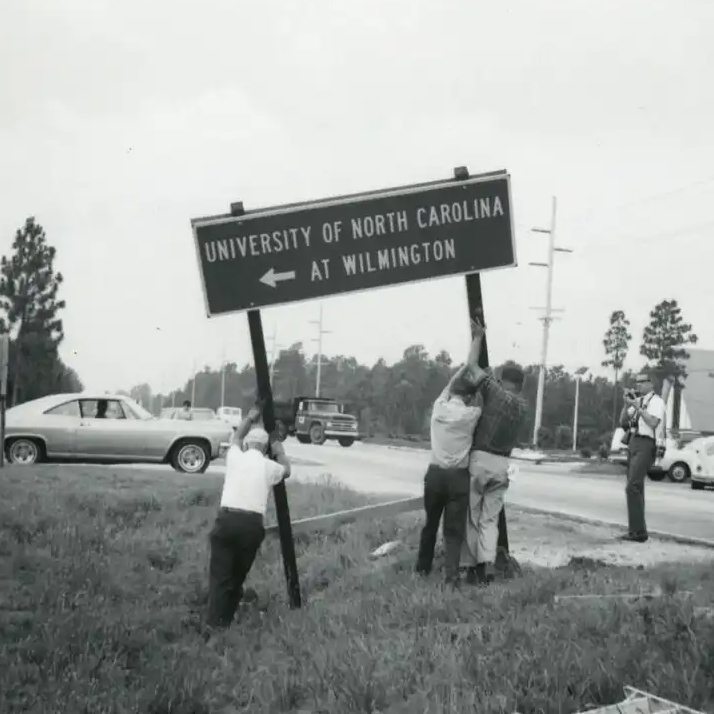 Crews installing a road sign for the recently renamed University of North Carolina Wilmington in 1969. Photo courtesy UNCW and the University Archives at Randall Library 
