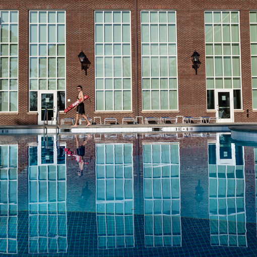 Photo of a lifeguard walking by the outdoor pool of the LSRC