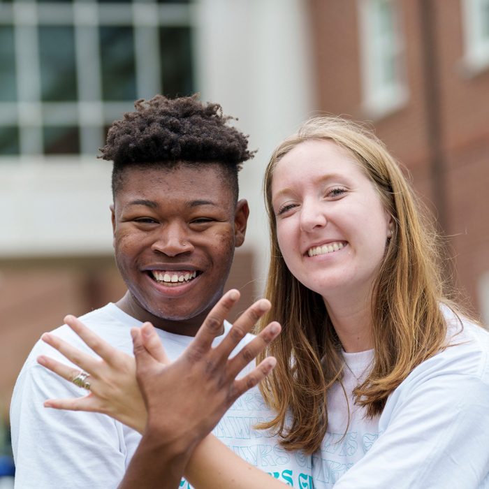Two students giving the seahawk hand sign