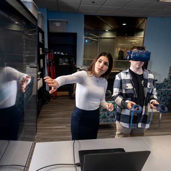 Teacher points to TV where VR headset is currently projected