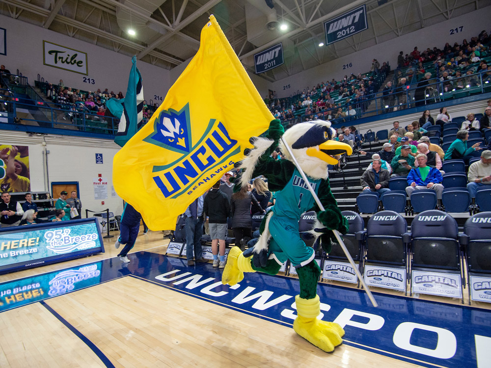 Sammy Seahawk Runs with a UNCW flag at a sports event