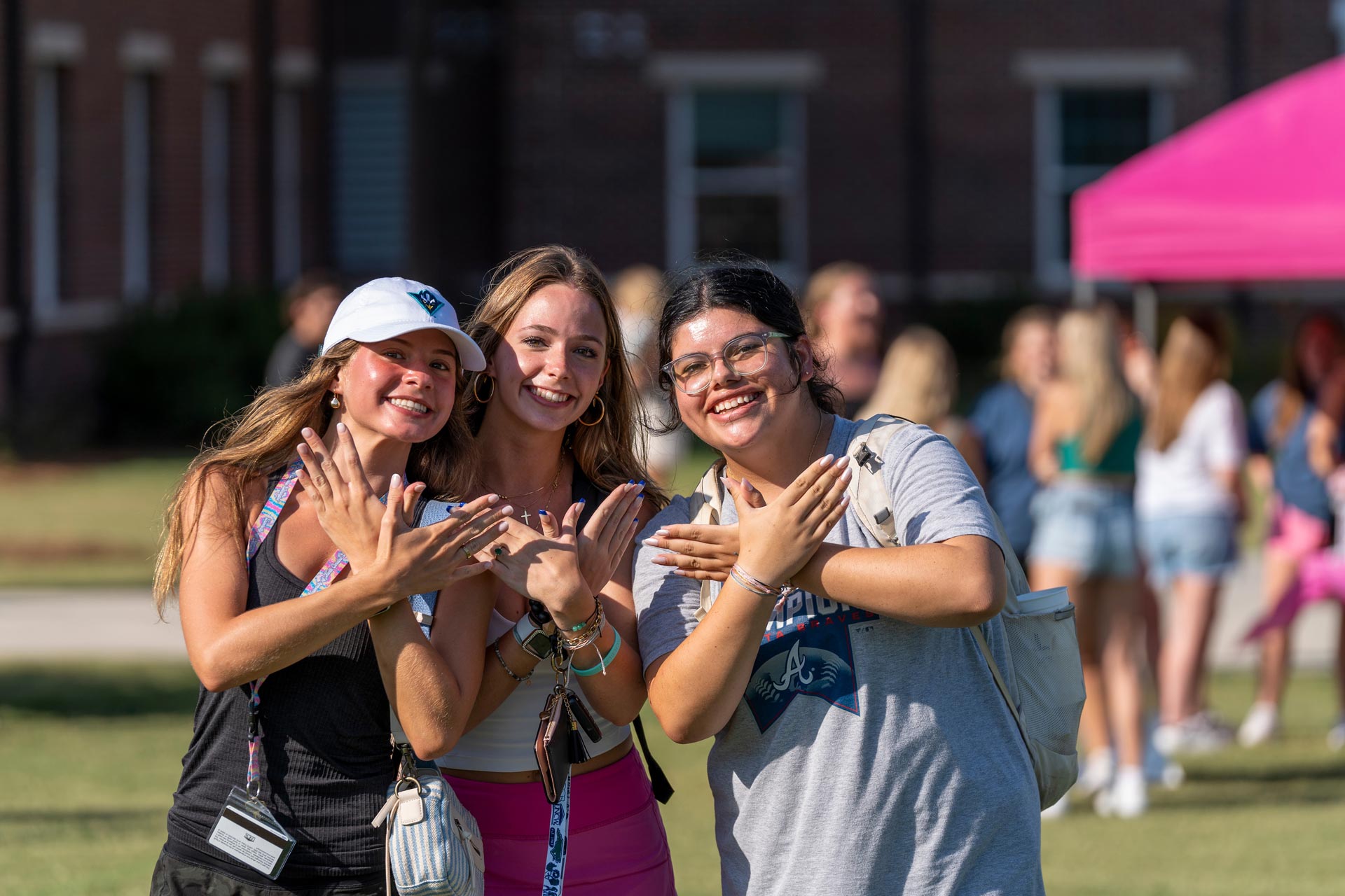Students posing with Wings Up salute at Fraternity and Sorority Life block party