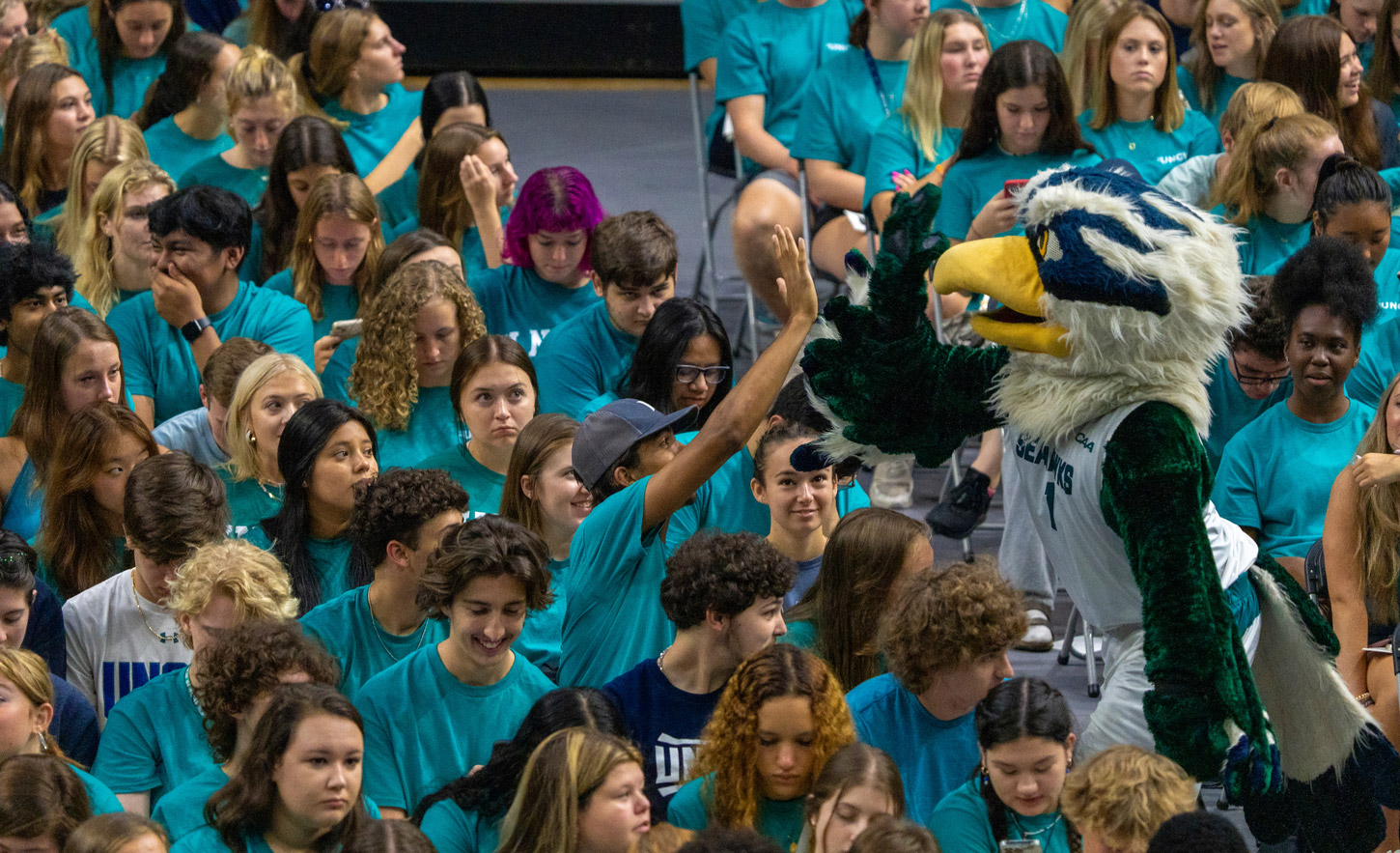Our mascot Sammy high fives a student