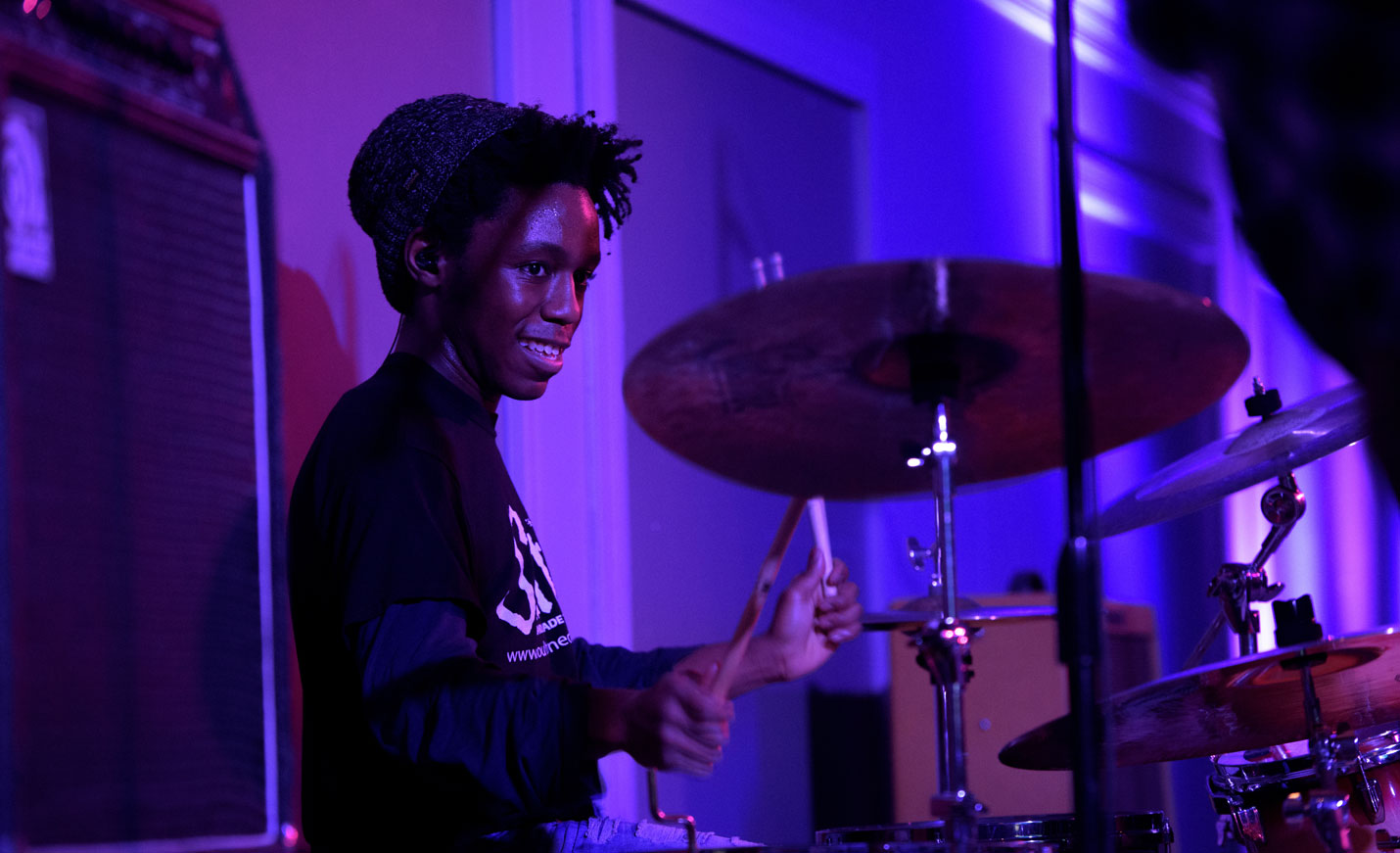 Student Drummer Participating in Battle of the Bands Competition with Purple Lights