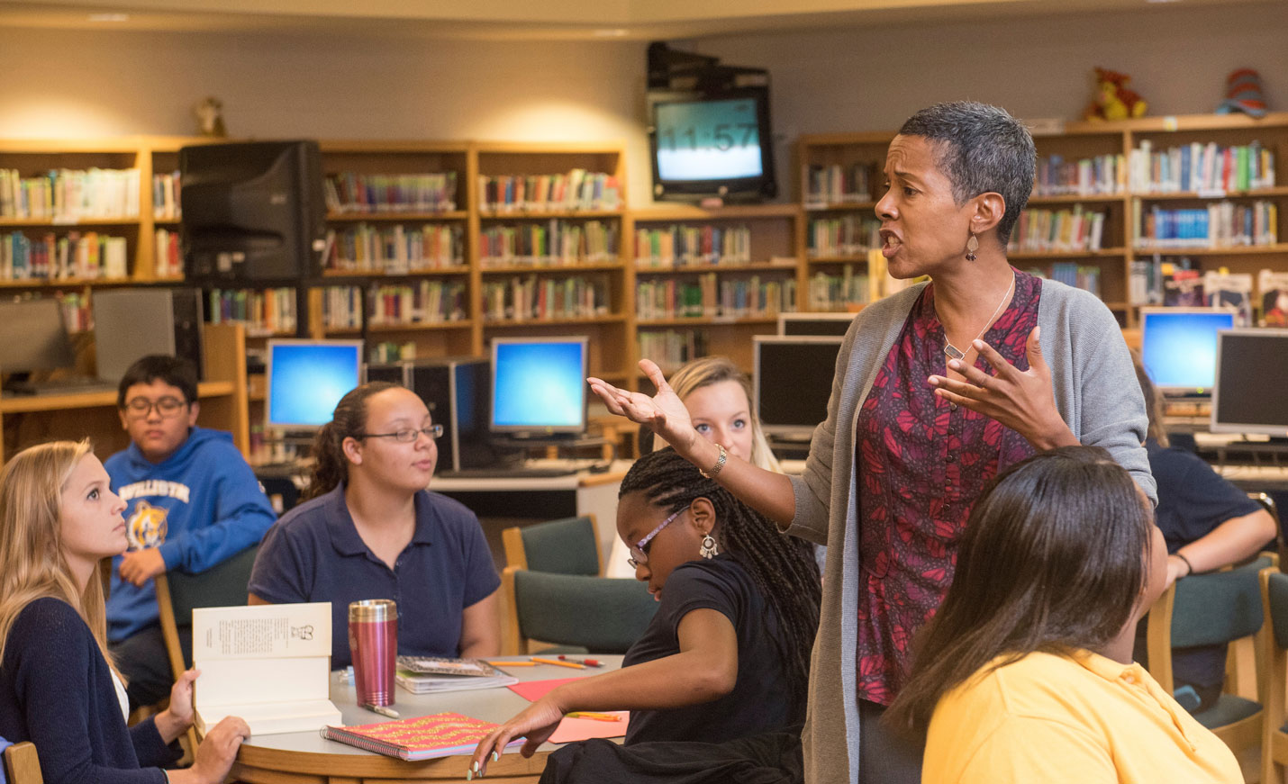 Woman speaking to students in a library