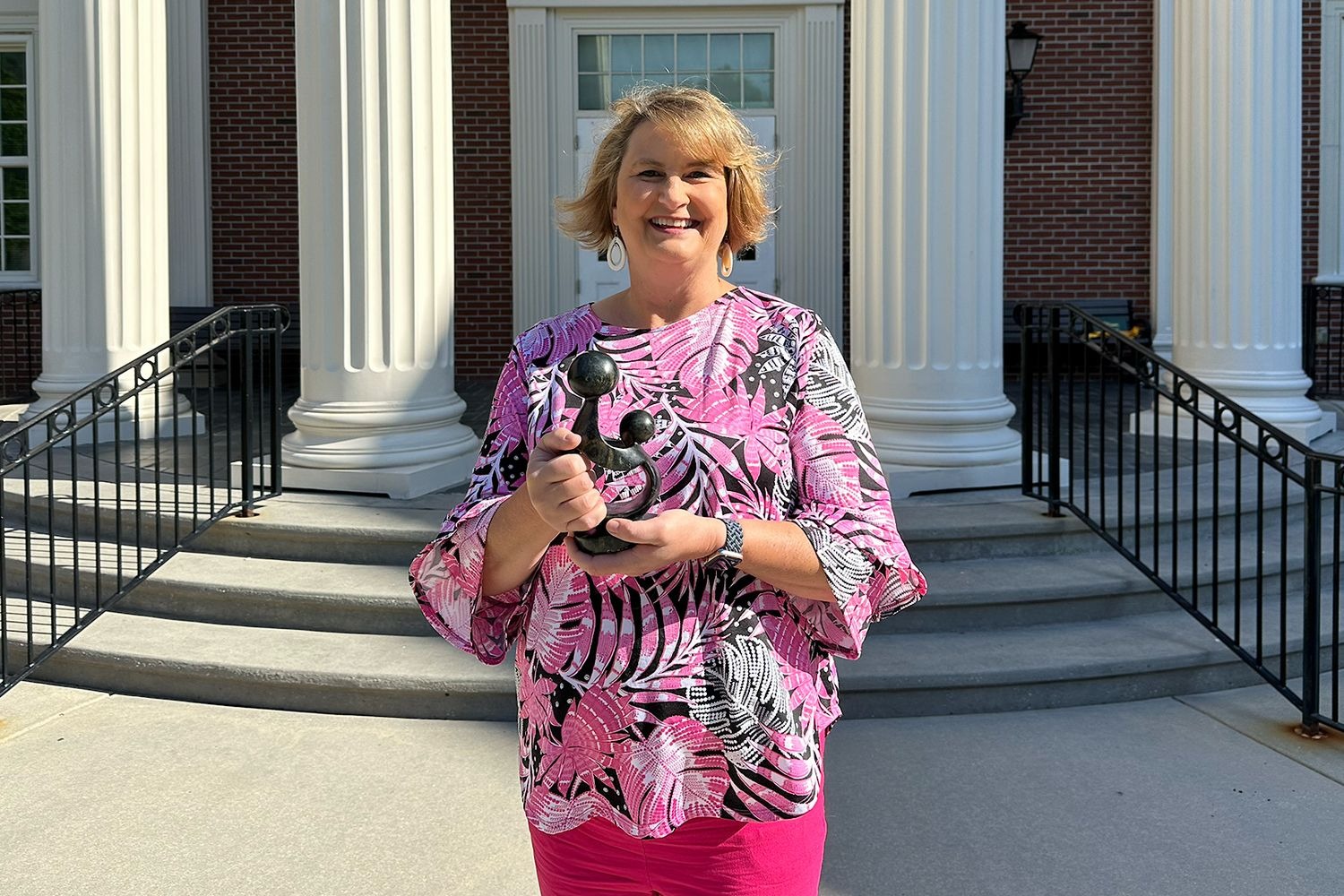 Dr. Nina Williams holds the Healer's Touch sculpture awarded to DAISY Honorees.