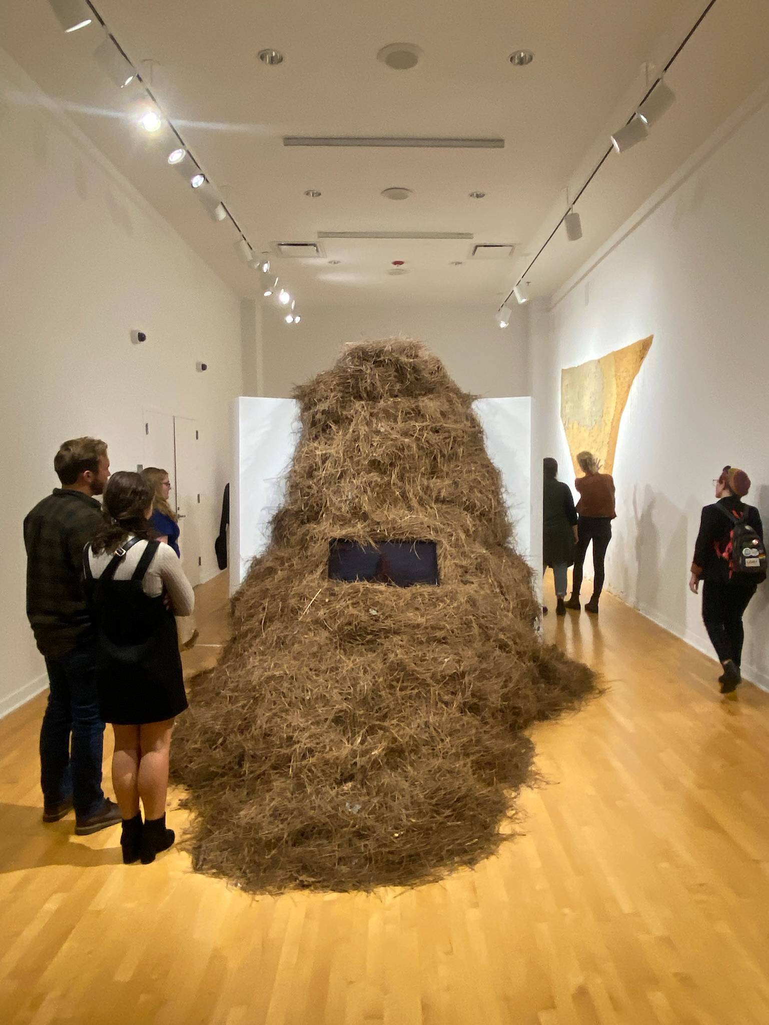 Kathryn Baczeski Exhibition with a large haystack sculpture with tv monitor in the middle