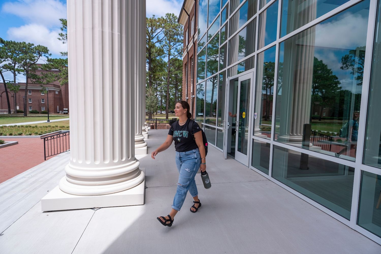 Student leaves Discovery Hall main entrance past column