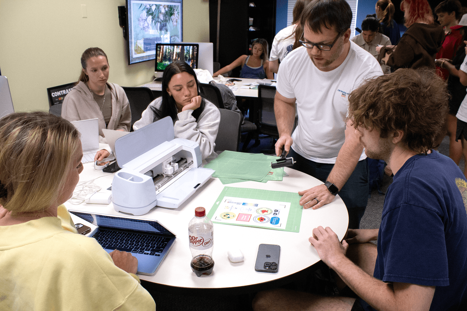 Students learn how to use a cutting machine to create promotional items