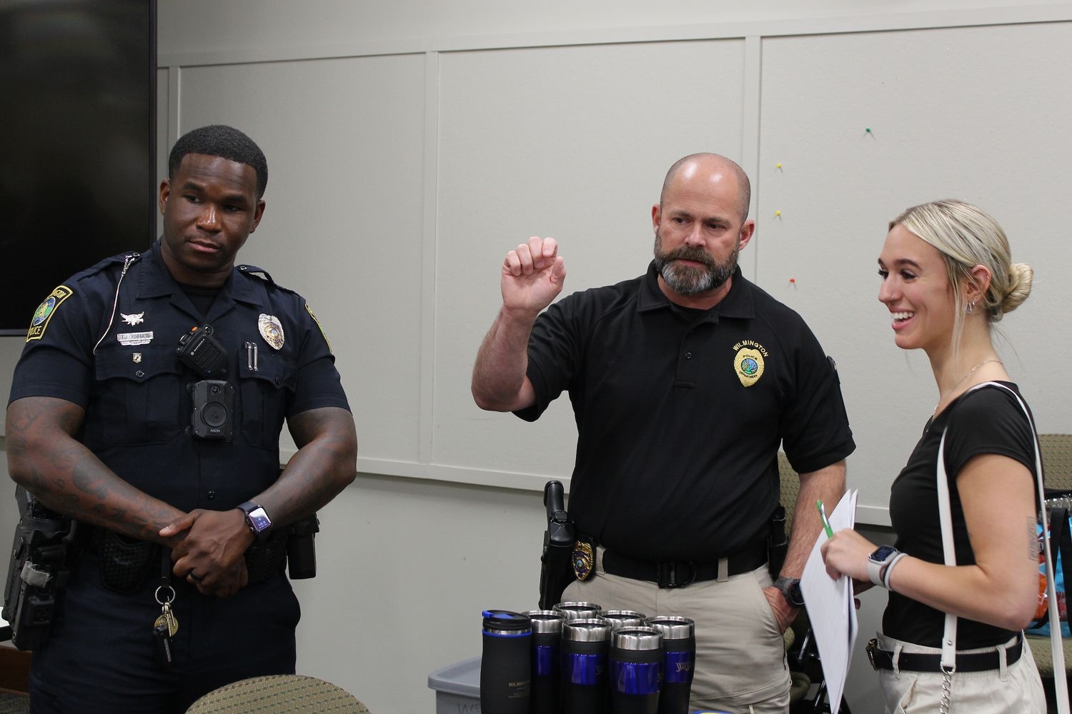 A student talks with regional law enforcement officers at a career fair