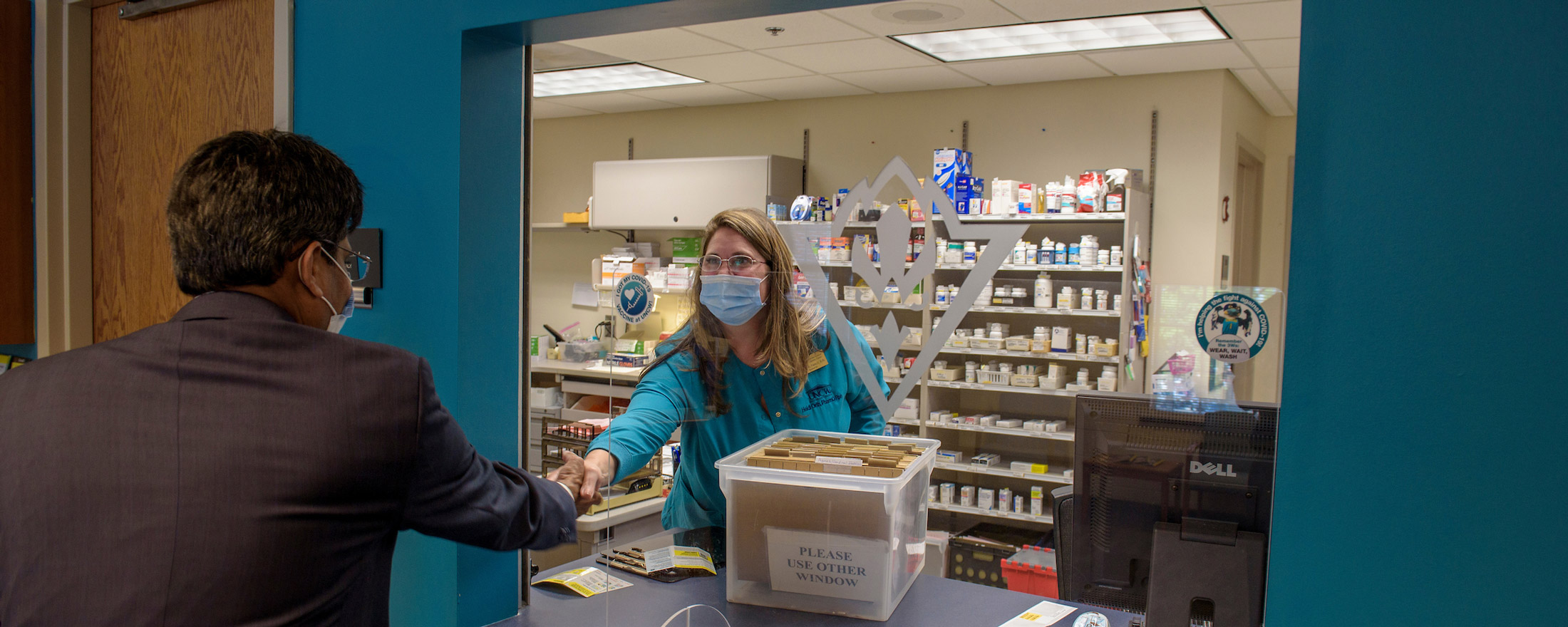 Chancellor Aswani Volety shakes the hand of pharmacist