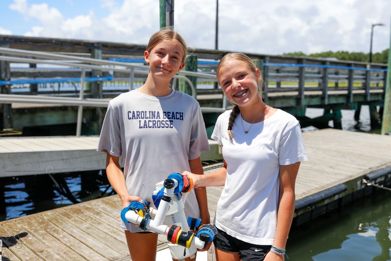 Two girls holding a buoy created at UNCW MarineQuest