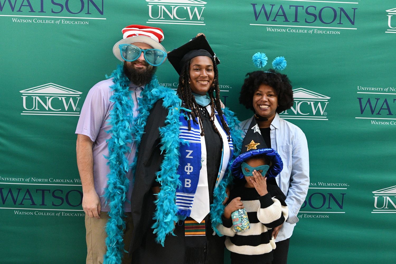 Family poses in silly hats and things in the photobooth