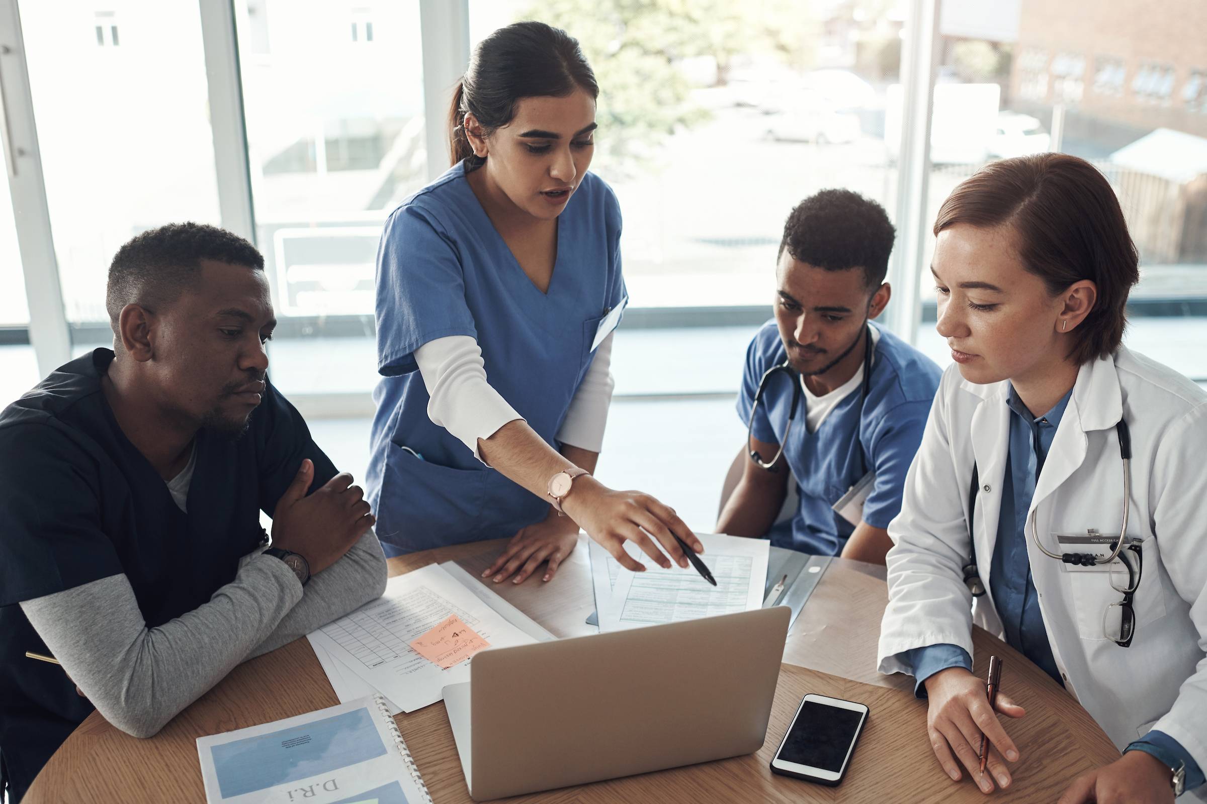 Clinical researchers discussing data around a computer