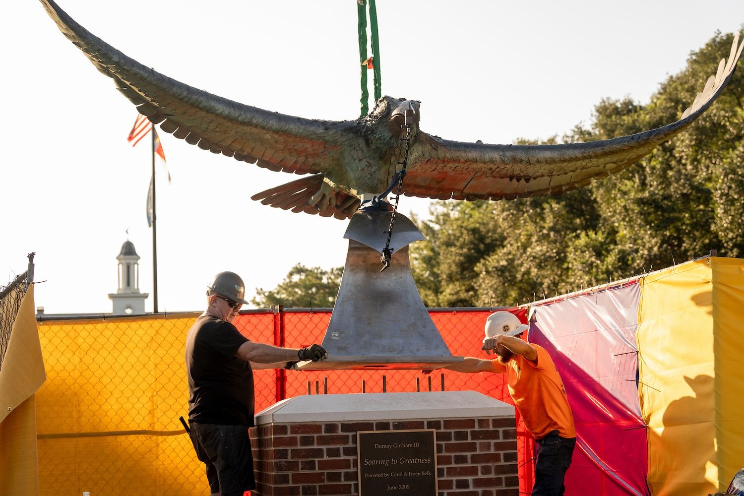Workers guide Soaring Seahawk statue onto pedestal