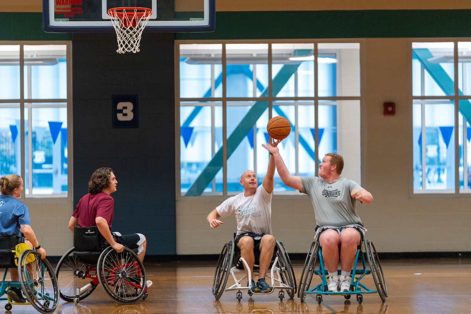 students play wheelchair basketball with faculty at the recreation center gym.