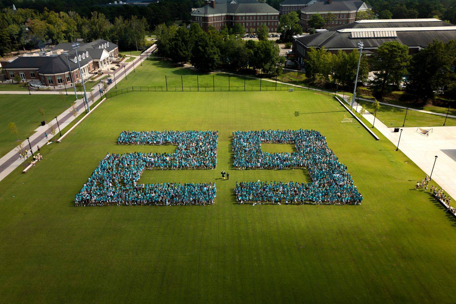 class of 2029 first year photo students gather on lawn to create a 29