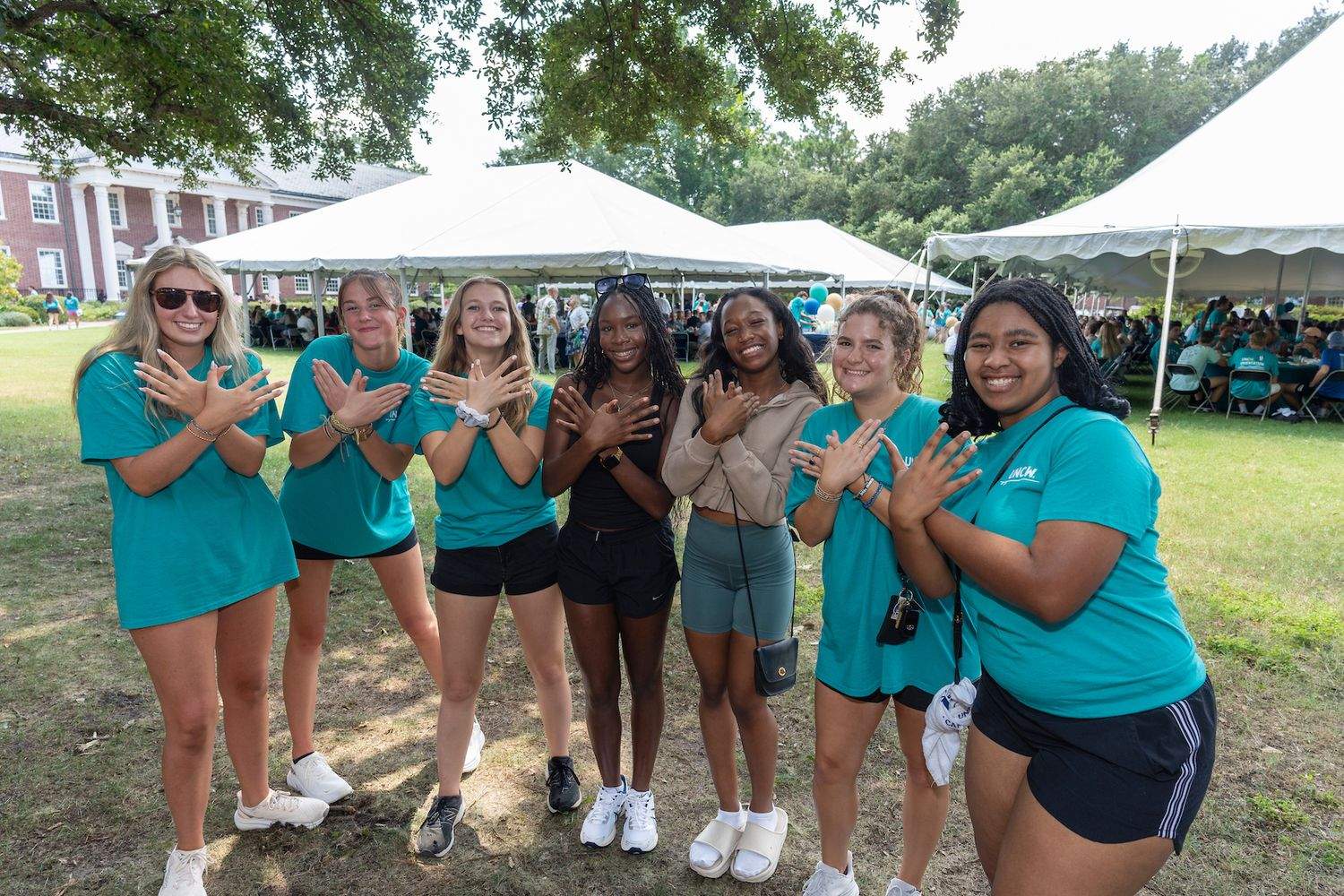 Students gathered for picnic making seahawk sign with hands
