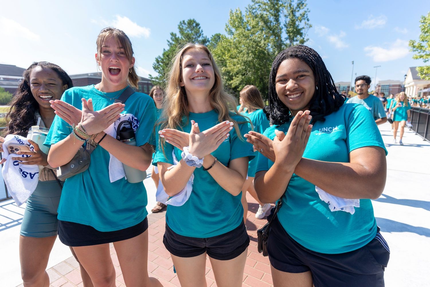 Three freshmen together with seahawk hand sign