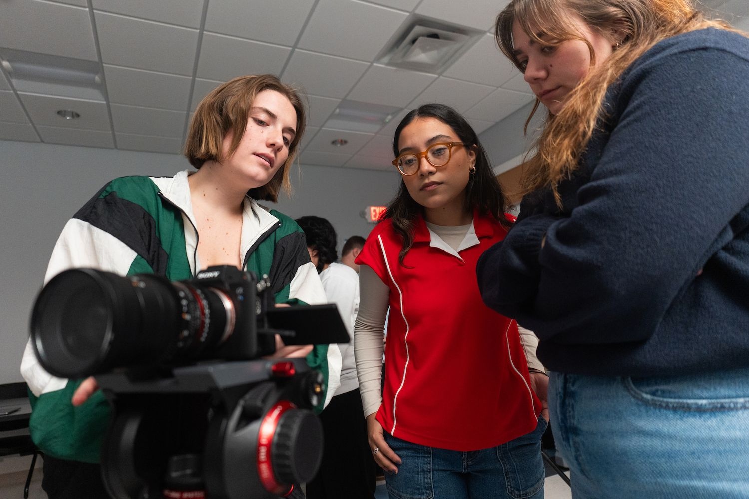 Film studies students gathered together around a camera