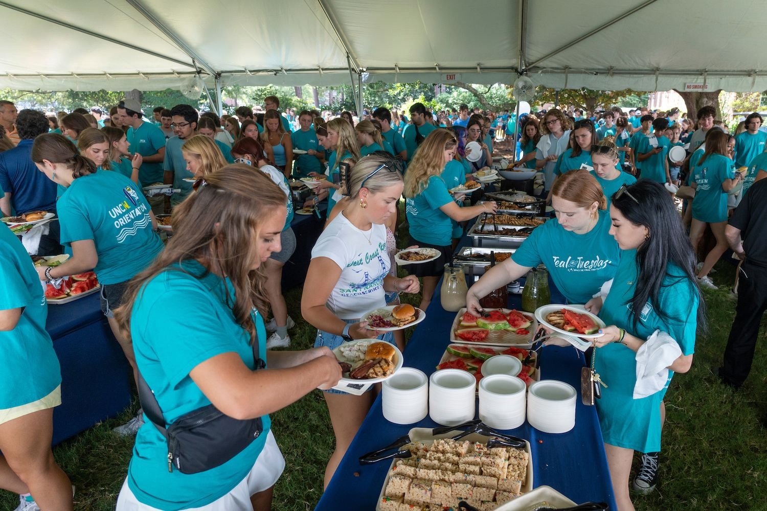 Students under a large tent for a picnic