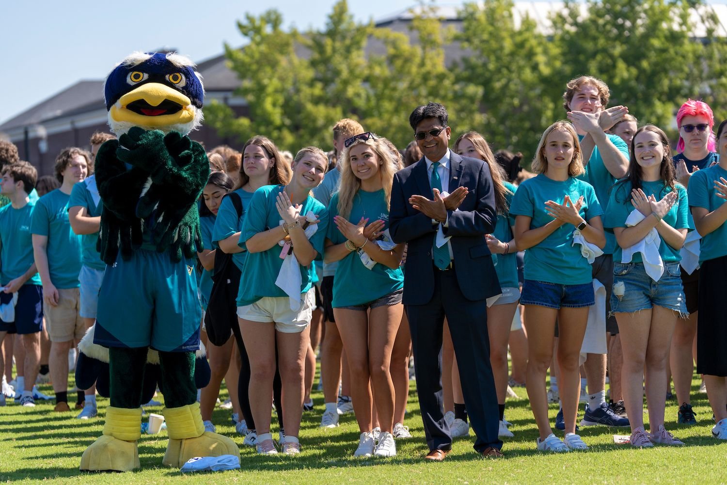 Students wearing teal t shirts with Chancellor Volety