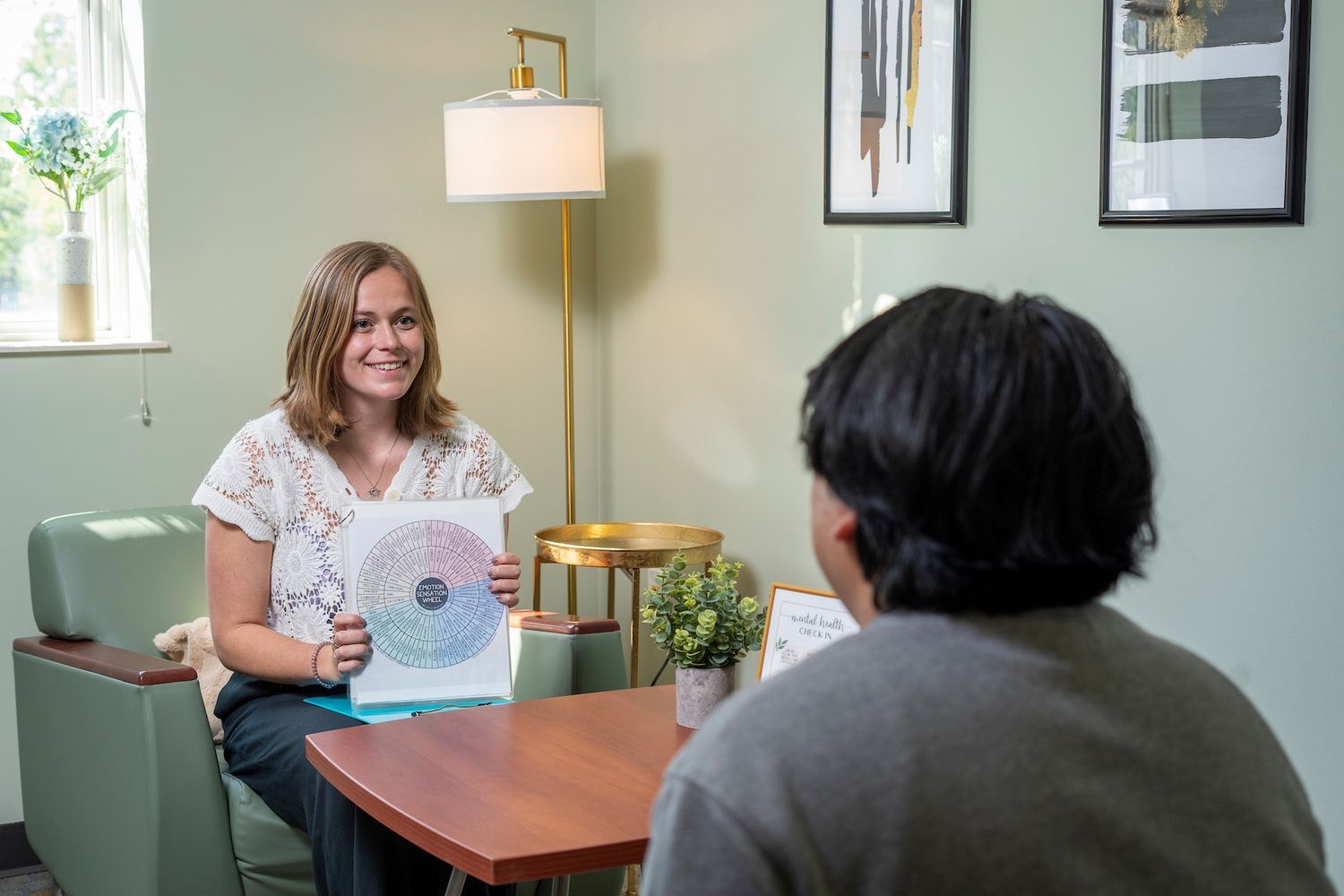 gpac member asking a student about the Emotion Sensation Wheel she is holding