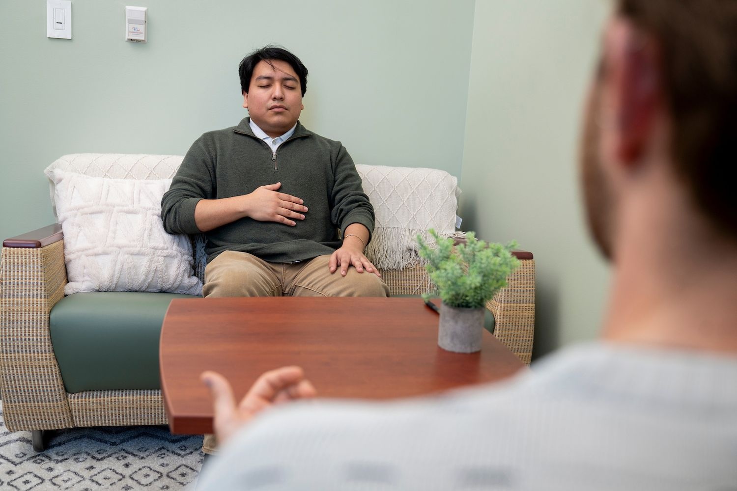 Two people sitting across from each other in a therapy office