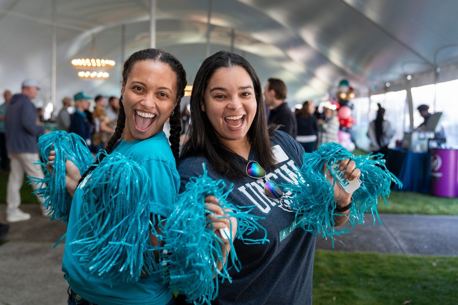 Sammy C. Hawk poses with people and the letters UNCW 
