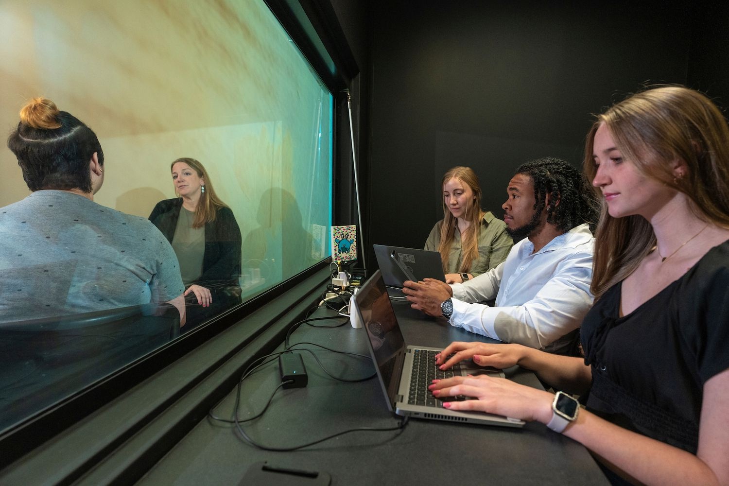 Researching students watch through one-way window