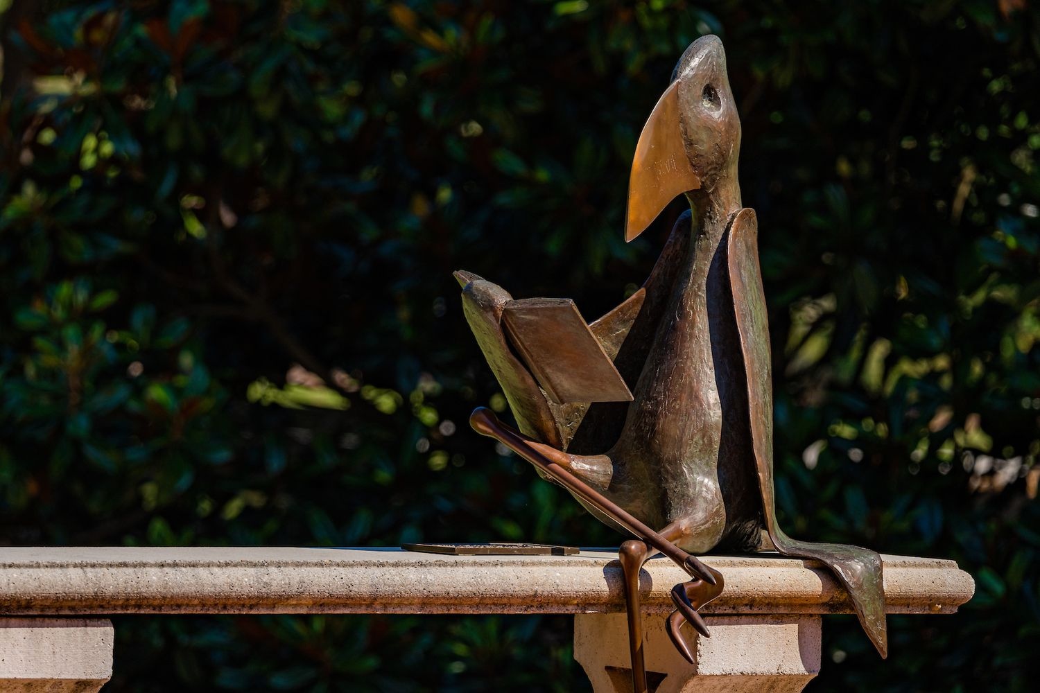 statue of a bird reading a book