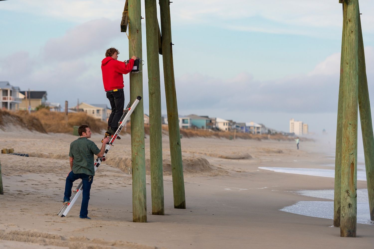 Students set up a field camera at Kure Beach Pier to monitor beach erosion.